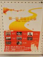 黄色とオレンジを基調としたデザインに、出演者や演目、日時・場所などの詳細情報が記載され、複数の人物やイベントの写真が添えられている「第一回芸能文化祭」ポスターの写真