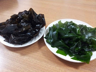 白い器に盛られたゆでる前の茶色の生わかめとゆがいたあとの緑色の生わかめの写真