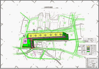 住宅用の区画が色分けされて横に並び、左側に集会所などの施設予定地が描かれた土地利用計画図の画像