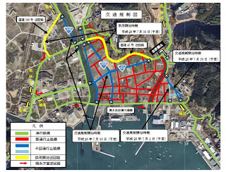 町全体の航空写真に交通規制の範囲や通行止めの区域、通行可能な道を色分けして表示した交通規制案内図の写真