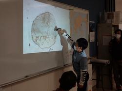 男の子がスクリーンに映し出された地図を指している様子の写真