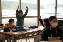 子どもたちが教室で手を挙げて喜んでいる様子の写真