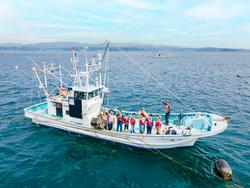 海に浮かんだ船の上にたくさんの子どもたちが乗っている写真