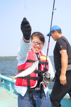 魚を釣って笑顔を見せている女の子の写真