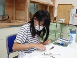 室内で海藻おしば作りに取り組む女の子の写真