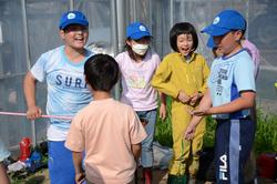 網を持った男の子の周りに集まった笑顔の子どもたちの写真