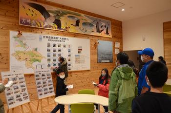 鳥のポスターや掲示物が貼られた資料館を見学している子どもたちの写真