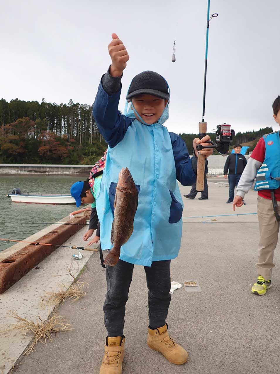 大きな魚が釣れて嬉しそうな男の子の写真