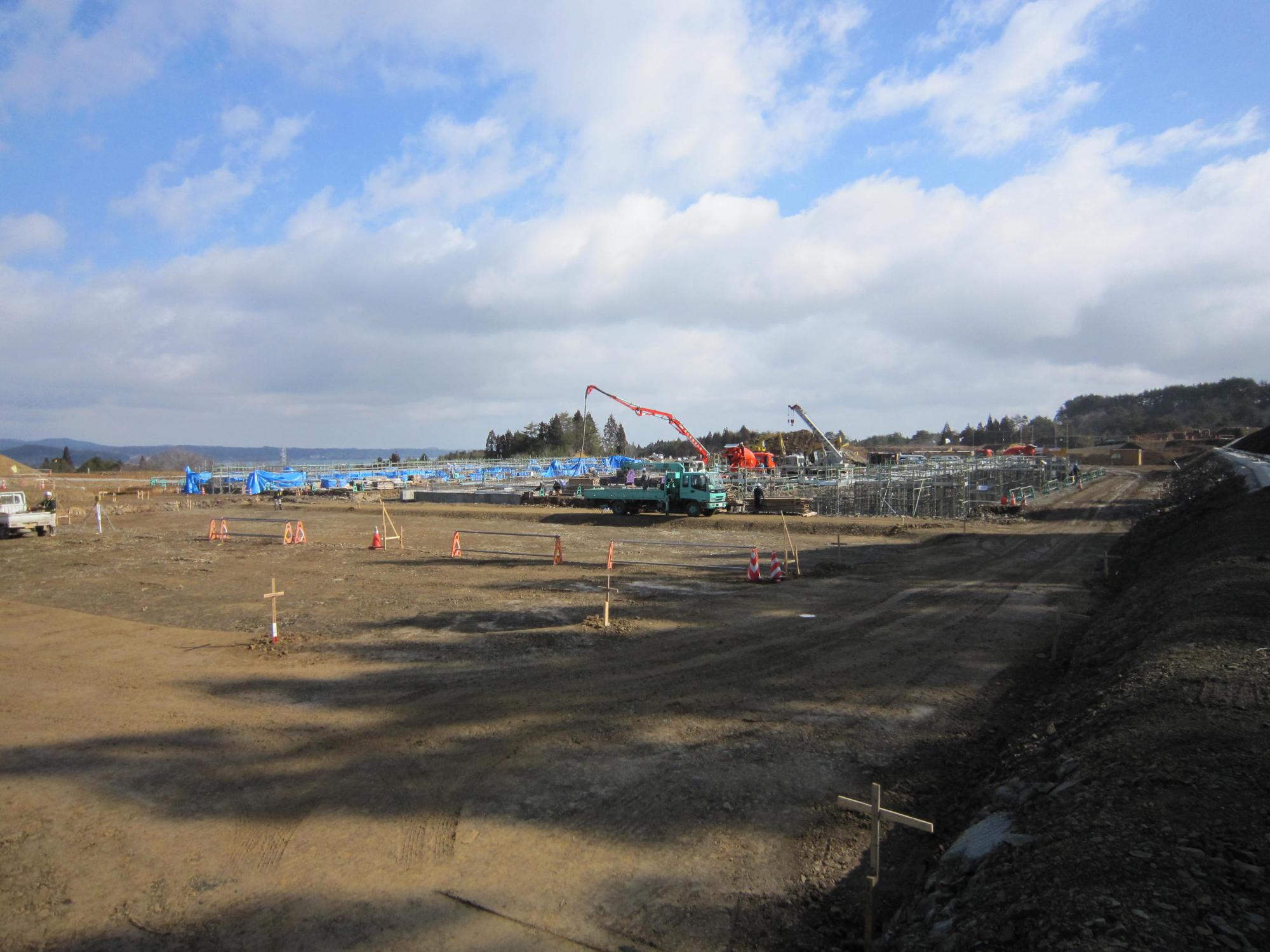 基礎工事が始まり、鉄骨や重機が配置された様子の写真