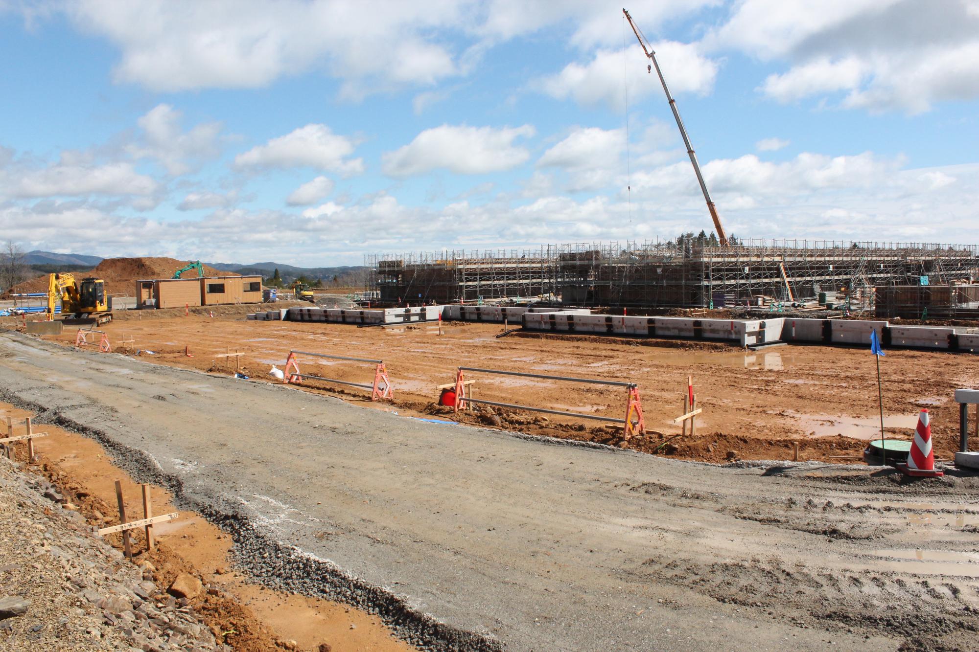 クレーンを使って建物の骨組みが立ち上がり始めた様子の写真