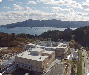 南三陸病院の奥に志津川湾が広がっている様子の写真