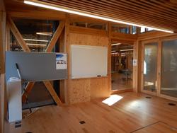 木材を多用した明るい室内に、白いホワイトボードとグレーの掲示板が設置されている青年の間・憩いの間の写真