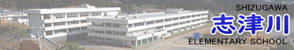 左側には、白い3階建ての長方形の校舎が斜めから撮影され右側には「SHIZUGAWA 志津川 ELEMENTARY SCHOOL」と、学校名が英語と日本語で書かれ「志津川」の文字は大きく青色で表現されたバナー