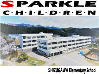 山々を背景に、満開の桜の木が立つ校庭の奥にある、白く大きな近代的な校舎を正面から捉えた学校の全景写真