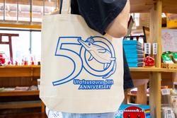 オリジナルグッズのエコバックを肩にかけている写真