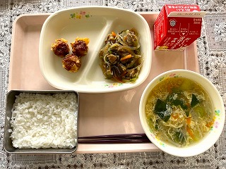 ピンクのトレーに給食が左から時計回りに揚げしゅうまい、夏野菜のチャプチェ、牛乳、たまごスープ、ごはんと並んでいる写真