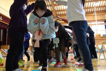 下級生の子ども達のアーチの下を楽しそうにくぐる6年生の児童を写した写真