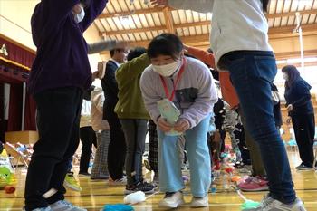 6年生たちが下級生のアーチの下をくぐりながら進んで退場している写真