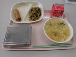 ピンクのトレイにご飯、はるまき、マーボーなす、中華コーンスープ、牛乳が並んだ給食の写真