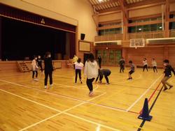 体育館内で児童と父兄の方々がドッジビーを楽しむ様子の写真