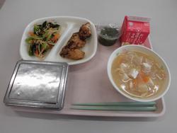 ピンクのトレイにご飯、ぶりのたつたあげ、小松菜のおひたし、めかぶとろろ、だいこんと油揚げの味噌汁、牛乳が並んだ給食の写真