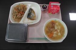 ピンクのトレイにご飯、れんこんのきんぴら、牛乳、油麩の味噌汁、ミニぶどうゼリーが並んだ給食の写真