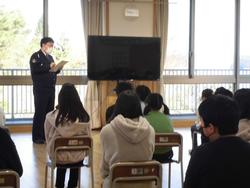 交通安全教室にて警察官の方が前で話をするのを椅子に座り聞いている児童達の写真