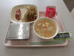 ピンクのトレイにご飯、赤魚のキムチ焼き、きんぴらごぼう、味付けのり、えのきと油揚げの味噌汁、牛乳が並んだ給食の写真