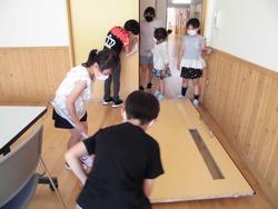 数人の子どもたちが協力して、教室内の清掃を行っている様子の写真