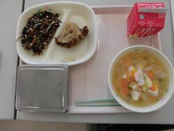 ピンクのトレイに、ご飯、鯖から揚げおろしソース、ひじきと切り干し大根の煮物、キャベツの味噌汁、牛乳が並んだ給食の写真
