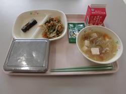 ピンクのトレーに、ごはん、さんまのおかか煮、豚肉とごぼうの味噌炒め、あぶら麩の味噌汁、ふりかけ、牛乳パックが並べられている給食の写真