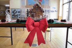 赤いリボンと一緒にテーブルに飾られた完成したお菓子の家の正面写真