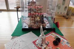 屋根にたくさんのマカロンや飾りが並んでいるお菓子の家を横から写した写真