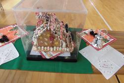 側面に星や小さな雪だるまの飾りがつけられたお菓子の家を上から撮った写真