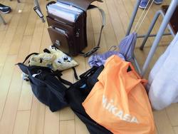 ランドセルやナップザック、手提げ袋などが床に無造作に置かれている写真