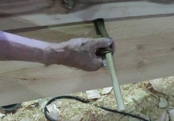 木の側面にクチヒキをあて、横に滑らせ墨を付ける作業をしている写真