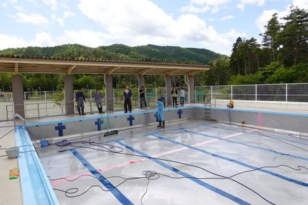 屋根付きの監視場所に先生達が立って綺麗になったプールを眺めている様子の写真