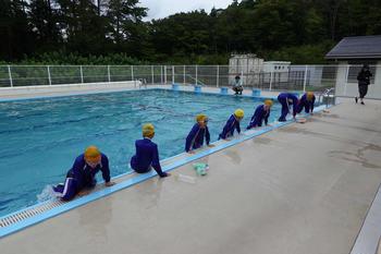 ジャージ姿の生徒たちがプールサイドに間隔をあけて上がっている様子を写した写真