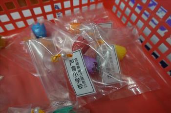 手作りの「繭マスコット」が赤いカゴに入っている写真