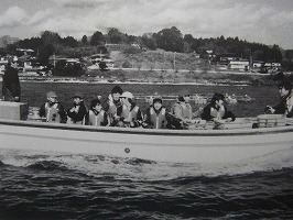 子どもたちがライフジャケットを着て船に乗っている洋上体験の様子のモノクロ写真