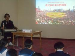 白い壁に株式会社楽天野球団のスライドが映し出された室内で、生徒たちが席に座っている様子の写真