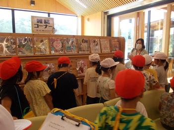 雑誌コーナーの前で女性から説明を受けている生徒たちの写真