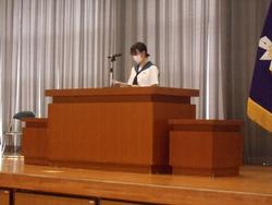 女子生徒が壇上の演台に立ち、原稿を読み上げている写真