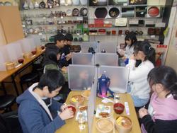 アクリル板で仕切られたテーブルで児童たちがわっぱめしの昼食を食べている写真