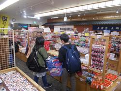 おみやげ店の中で児童たちが商品を見て選んでいる様子の写真