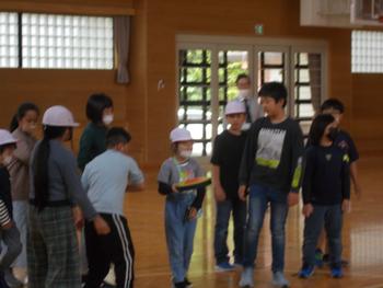 体育館内で児童がたて割り班で集まりドッチビーを楽しんでいる写真