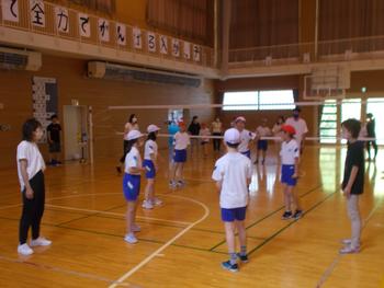 体育館内で親子ビニールバレーボール大会のコートに立つている児童5名、保護者2名の写真