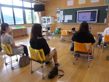 椅子に座って懇親会に参加しているお母さんたちを後方から写した写真