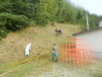 竹林の草刈りをしている男性4名の写真