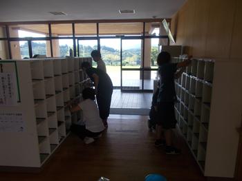 靴箱の中を丁寧に掃除している関係者数名の写真